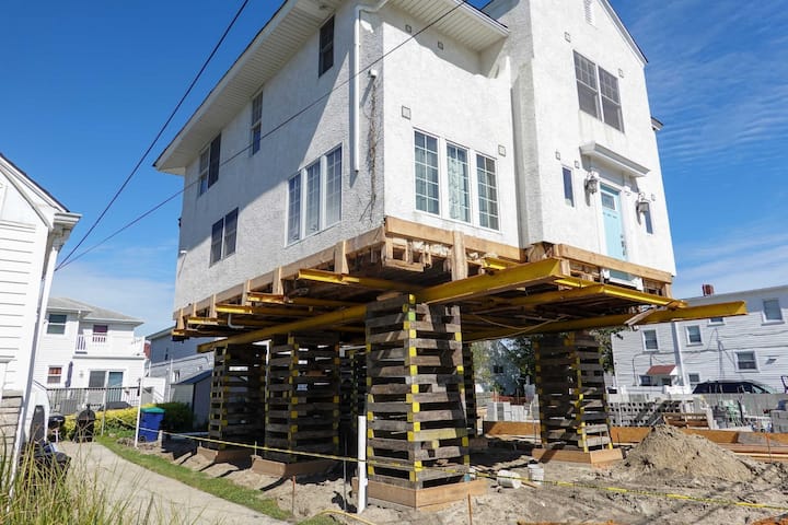 A team of professionals using specialized equipment to raise a house in San Marcos, preparing it for elevation and renovation